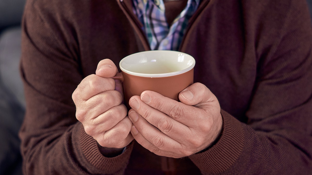 Man holding the cup, closes the shot